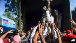 Des soldats distribuent l’aide humanitaire russe au point de contrôle de Homs, Syrie, 13 septembre 2017.