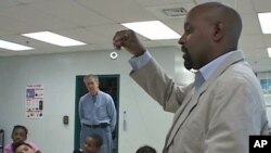 Teacher Fred Tenyke discusses science with the class at Georgian Forest Elementary school as retired engineer Dave Weiss, who helps apply his experience to help, looks on, in Silver Spring, Maryland, November 2011.