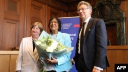 南非律师、国际法倡导者纳维·皮莱(Navi Pillay，中)在纽伦堡司法宫具有历史意义的600号法庭发表新闻声明后，与国际刑事法院(ICC)前院长西尔维娅·费尔南德斯·德·古尔门迪(Silvia Fernandez de Gurmendi，左)及纽伦堡国际原则学院院长克里斯托夫·萨弗林(Christoph Safferling，右)合影留念。(2026年10月9日)