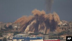 Asap dan puing-puing bangunan menghambur ke atas menyusul serangan Israel di Jalur Gaza (9/7). (AP/Ariel Schalit)