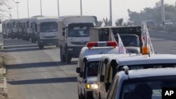 FILE - A convoy of trucks loaded with humanitarian supplies are seen heading to the besieged town of Madaya, about 40 kilometers northwest of Damascus, Syria, for a U.N.-aid distribution, Jan. 14, 2016.