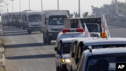 FILE - A convoy of trucks loaded with humanitarian supplies heads to the besieged town of Madaya, 24 kilometers southwest of Damascus, Syria, Jan. 14, 2016.