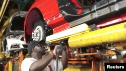 FILE - An assembly worker works on 2015 Ford Mustang vehicles on the production line at the Ford Motor Flat Rock Assembly Plant in Flat Rock, Michigan, Aug. 20, 2015. 