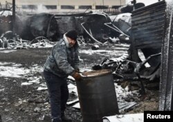A man inspects damage at an oil depot hit by recent shelling in the course of the Russia-Ukraine war in Donetsk, Russian-controlled Ukraine, on Dec. 7, 2023.