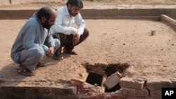 Pakistani villagers look at damage to their roof caused by mortar allegedly fired by Indian forces at the border village of Chaprar situated on the Pakistan-Indian border, in Pakistan, Oct. 26, 2016. 