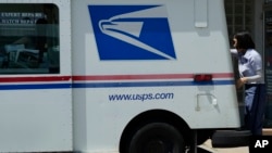 FILE - A U.S. Postal Service employee makes deliveries in Northbrook, Ill., June 3, 2024. Election officials across the U.S. are warning that problems with mail delivery threaten to disenfranchise voters in the upcoming presidential election. 