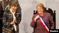 FILE - Chile's President Michelle Bachelet smiles next to Senate President Isabel Allende (L), daughter of late former President Salvador Allende, after delivering her annual address at the national congress building in Valparaiso city, northwest of Santiago, May 21, 2014.
