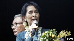 Aung San Suu Kyi saat memberikan pidato di hadapan pendukungnya di markas besar Partai Liga Demokrasi Nasional (NLD) pada hari Minggu.