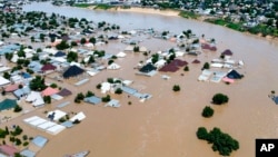 FILE - Homes and other buildings are partially submerged following a dam collapse, in Maiduguri, Nigeria, Sept 10, 2024.