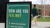 FILE - A sign at the University of Vermont reminds students to monitor their symptoms during the coronavirus pandemic, in Burlington, Vermont, April 27, 2021. 