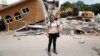 FILE - Ana Maria Hernandez, 37, a clothing salesperson, stands outside her house as it is demolished after an earthquake in Jojutla de Juarez, Mexico, Sept. 30, 2017. 