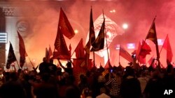 Opponents of the deal between Greece and Macedonia on the latter country's new name "North Macedonia" light flares protesting outside the parliament in Skopje, Macedonia, June 17, 2018.