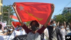 지난 14일 미얀마 양곤에서 열린 군부 쿠데타 반대 시위 현장에서 아웅산 수치 국가고문이 이끄는 ‘민주주의민족동맹(NLD)’ 깃발을 들고 있다.