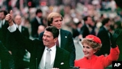 President Ronald Reagan gives a thumbs up to the crowd while his wife, first lady Nancy Reagan, waves from a limousine during the inaugural parade in Washington following Reagan's swearing in as the 40th president of the United States, (File).