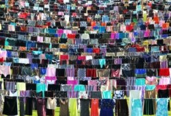 5,000 dresses and skirts hang inside a stadium, in an exhibition titled "Thinking of You" by Kosovo-born Alketa Xhafa-Mripa, in Pristina, June 2015. The artist hoped to draw attention to the stigma suffered by victims of wartime sexual violence.