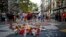 巴塞罗那历史悠久的兰布拉大道(Las Ramblas)上，一名女子在纪念仪式周围放了一朵花，悼念2017年恐怖袭击的遇难者。(2018年8月16日)