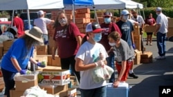  Image Description Utah Food Bank volunteers assemble bags of food to be delivered to waiting cars at the food bank's mobile food pantry Aug. 12, 2020, in Salt Lake City, during the coronavirus pandemic.