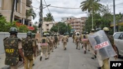 Police personnel patrol a street after violence broke out overnight following a "derogatory" Facebook post about the Prophet Mohammed, in Bangalore, Aug. 12, 2020.