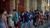 People wearing face masks wait their turn to be called for a PCR test for the COVID-19 at Vilafranca del Penedes in the Barcelona province, Spain, Aug. 10, 2020. 