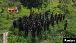 Una vista aérea muestra a los guerrilleros del grupo rebelde colombiano Segunda Marquetalia de pie en formación frente a una pancarta con los colores de la bandera nacional de Colombia en julio 25, 2024.