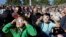 A crowd wears protective glasses as they watch the beginning of the solar eclipse from Salem, Oregon, Aug. 21, 2017.