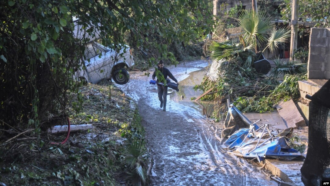 Seseorang melewati jalan yang dilanda banjir dekat sebuah rumah di mana sembilan orang meninggal akibat air meluap dari sungai di Casteldaccia dekat Palermo, Sisilia (4/11).