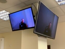 Russian opposition figure Alexey Navalny is seen on screens via video link before a hearing, in Moscow, April 29, 2021. (Press Service of Babushkinsky District Court of Moscow/Handout)