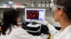 Dr. Sonia Macieiewski (R) and Dr. Nita Patel, Director of Antibody discovery and Vaccine development, look at a sample of a respiratory virus at Novavax labs in Rockville, Maryland, one of the labs developing a vaccine for the coronavirus.