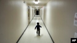 FILE - An asylum-seeking boy from Central America runs down a hallway after arriving from an immigration detention center to a shelter in San Diego, Dec. 11, 2018.