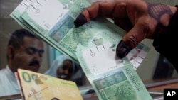A woman displays Sudan's new currency at the central bank in Khartoum, Sudan, (File photo).