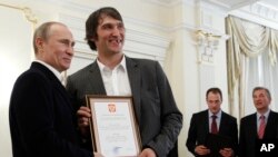 FILE - Russian national ice hockey team member Alexander Ovechkin, right, holds a certficate of recognition given to him by President Vladimir Putin, left, in the Novo-Ogaryovo residence outside Moscow, Tuesday, May 29, 2012.