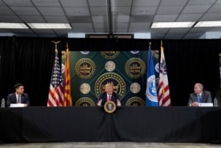 Chad Wolf, acting Secretary of the Department of Homeland Security, left, and Mark Morgan, Acting Commissioner of the United States Customs and Border Protection, listen as President Donald Trump speaks in Yuma, Ariz., June 23, 2020.