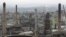 FILE - Chimneys from the Engen oil company are seen on the outskirts of the city of Durban, South Africa, Nov. 30, 2011.