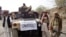 Armed militants of Tehreek-e-Taliban Pakistan (TTP) pose for photographs next to a captured armored vehicle in the Pakistan-Afghanistan border town of Landikotal on November 10, 2008, after they hijacked supply trucks bound for Afghanistan.