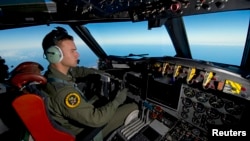 A Royal Australian Air Force pilot steers his AP-3C Orion over the Southern Indian Ocean during the search for missing Malaysian Airlines flight MH370 in this picture released by the Australian Defense Force, March 20, 2014.