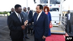 This handout picture taken and released on Oct. 21, 2024, by Cameroon's Presidential Press Office shows Cameroon's President Paul Biya, center, and his wife Chantal Biya (center-right) greeted upon their return, at the Yaounde Nsimalem International Airport. 