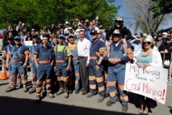 FILE - Coal miners stand with Republican presidential candidate, former Massachusetts Gov. Mitt Romney when he campaigned in Craig, Colo., May 29, 2012.