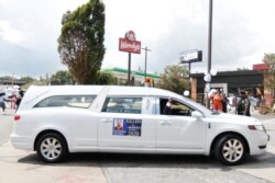 A hearse carying the casket of Rayshard Brooks passes by the area where he was killed near a Wendy's restaurant on Tuesday, June 23, 2020, in Atlanta. The funeral of Brooks was held today.