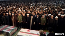 Pemimpin tertinggi Iran Ayatollah Ali Khamenei dan Presiden Hassan Rouhani berdoa di dekat jenazah Mayjen Iran Qassem Soleiman dan komandan militan Irak Abu Mahdi al-Muhandis yang terbunuh akibat serangan udara AS, di Teheran, Iran, 6 Januari 2020. (Foto: kantor Khamenei/REUTERS)