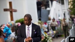 Anggota jemaat gereja meninggalkan acara penghormatan bagi Senator Clementa Pinckney, salah satu dari sembilan korban penembakan di Gereja AME Emanuel di Charleston, South Carolina (25/6). (AP/David Goldman)