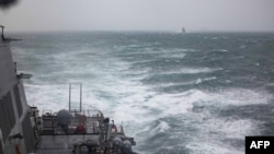 Kapal perang USS Higgins (DDG-76), dan kapal perang Kapal perang Kanada HMCS Vancouver (FFH 331), yang berada di belakang, berlayar melewati Selat Taiwan, pada 20 Oktober 2024. (Foto: Trevor Hale/US NAVY/AFP)