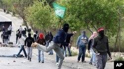 Palestinian youths throw stones at Israeli soldiers during clashes in the East Jerusalem neighborhood of Issawiya, 16 Mar 2010