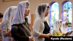 Local residents pray for victims of the 1945 atomic bombing during a mass at the Urakami Cathedral in Nagasaki, western Japan, on the 68th anniversary of the bombing of Nagasaki, in this photo taken by Kyodo, Aug. 9, 2013.
