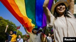 FILE - Participants hold a rainbow flag during the Tokyo Rainbow Pride parade in Tokyo, April 26, 2015. A human rights group said May 5 that Japan has failed to protect its lesbian, gay, bisexual and transgender (LGBT) students. 