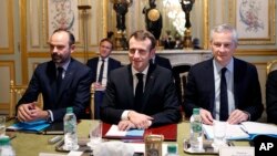 France's President Emmanuel Macron, center, France's Prime Minister Edouard Philippe, left, and France's Finance Minister Bruno Le Maire, right, attend a meeting with the representatives of the banking sector at the Elysee Palace, in Paris, Dec.11, 2018.