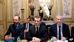 France's President Emmanuel Macron, center, France's Prime Minister Edouard Philippe, left, and France's Finance Minister Bruno Le Maire, right, attend a meeting with the representatives of the banking sector at the Elysee Palace, in Paris, Dec.11, 2018.