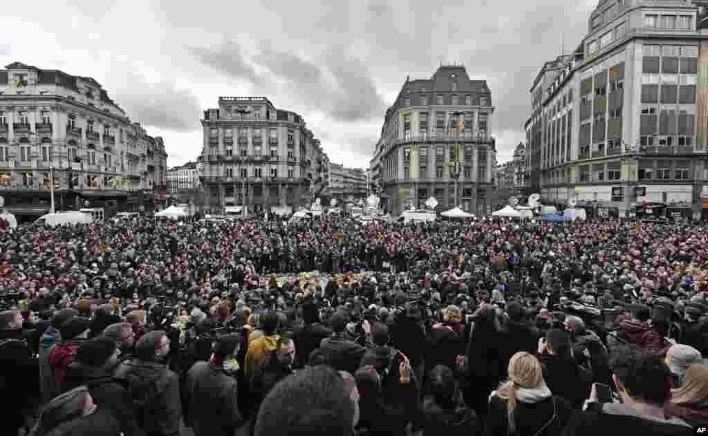 People observe a minute of silence at the Place de la Bourse in the center of Brussels, March 23, 2016.