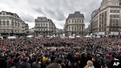 Les gens observent une minute de silence à la Place de la Bourse dans le centre de Bruxelles, le 23 Mars , ici 2016. (AP Photo/Martin Meissner)