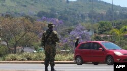 Un soldat se tient sur la route à Manzini le 20 octobre 2021.