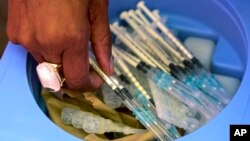 Un agent de santé prend des seringues pour vacciner des personnes contre le coronavirus à Johannesburg, en Afrique du Sud, le 25 mai 2021.